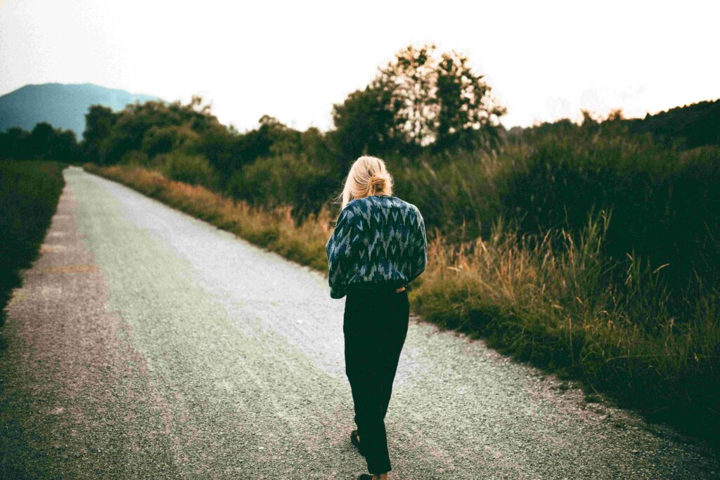 A woman walking alone on a road to clear her mind when she feels like she detests her husband.