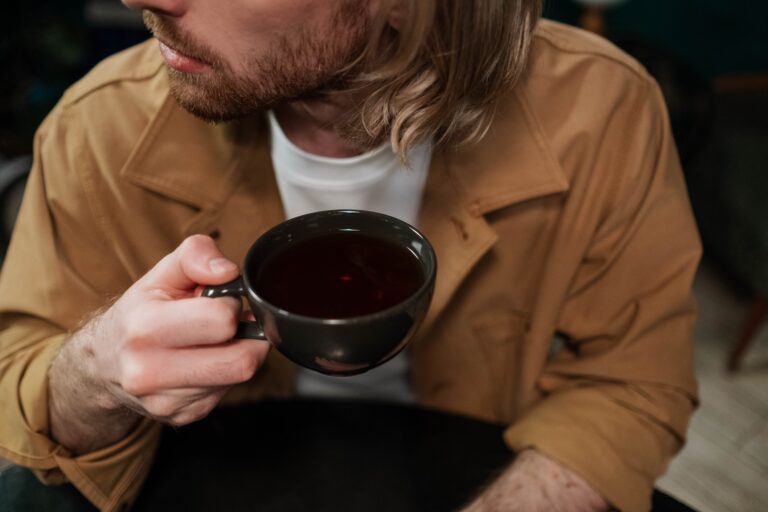 How to Tell Someone You Like Them: 19 Subtle Ways to Confess Close up of a man holding a coffee cup while considering how to tell someone you like them over a date.