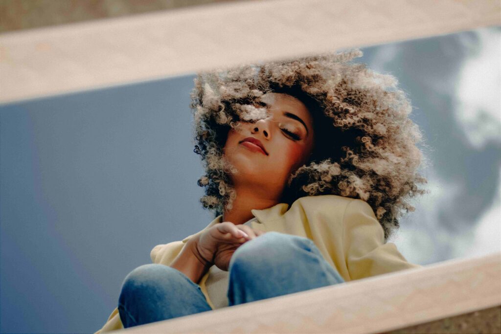 A serene woman relaxing with eyes closed, embodying peace and how to get someone to like you naturally.