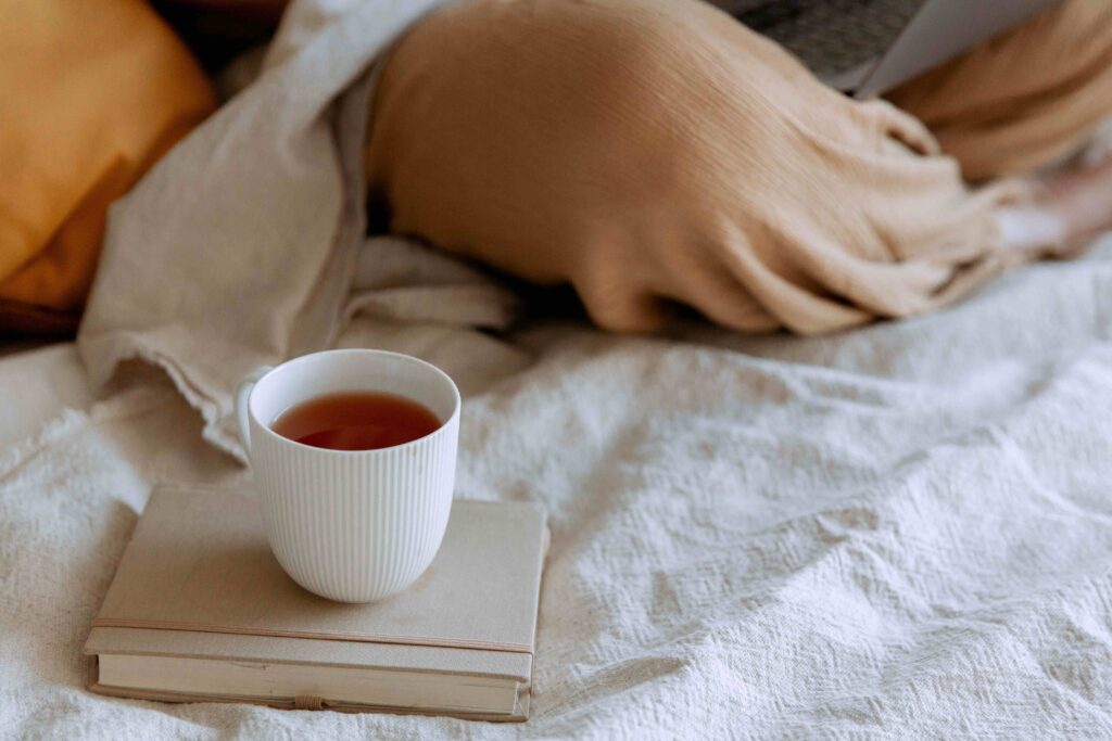 A cozy setup with a cup of tea on a book with blankets, perfect for Monday morning blessings.