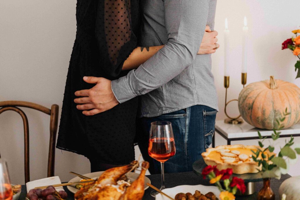 Tense couple hugging tightly in the kitchen, dealing with hidden anger toward husband.
