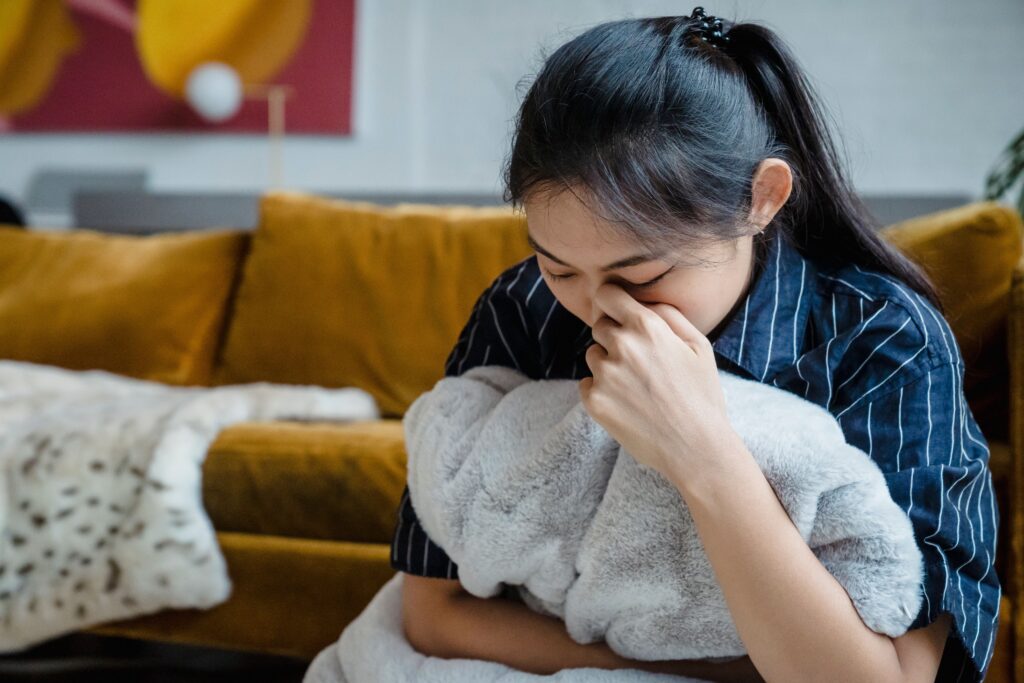 Anxious girl crying on the floor while hugging a cushion, feeling insecure because my boyfriend is cold.