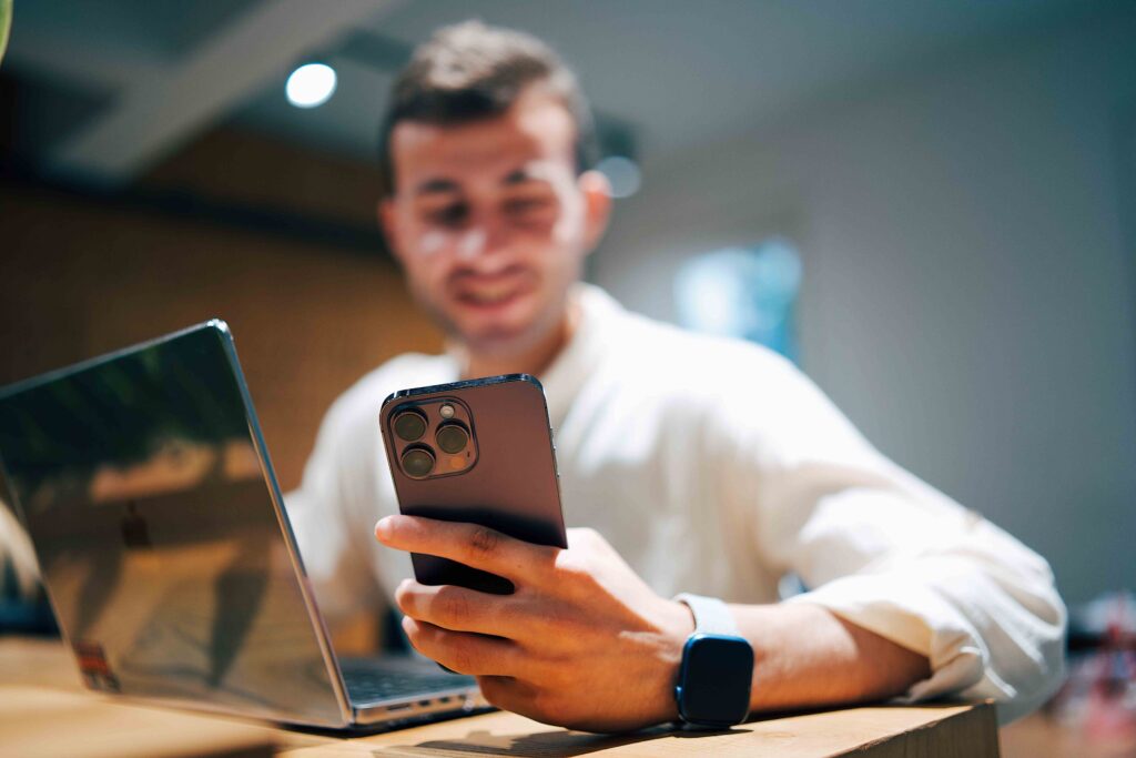 The 10-Second Text That Will Make Him Smile for Hours (Copy & Paste) A man smiling at his phone. The 10-second text that will make him smile.