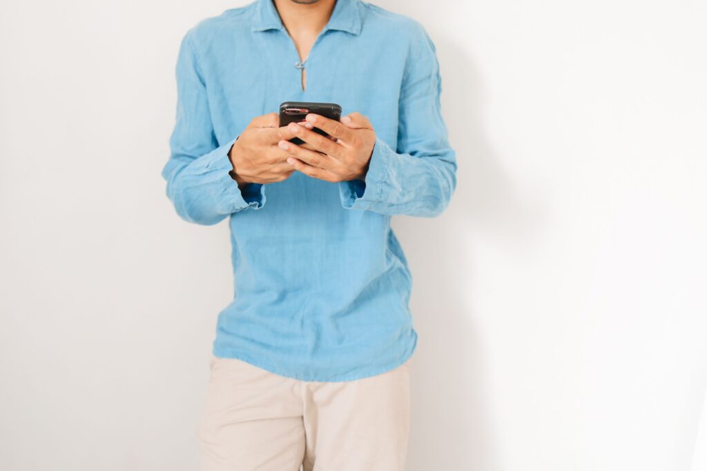 A person holding a phone, ready to text your crush by replying to their social media story. 