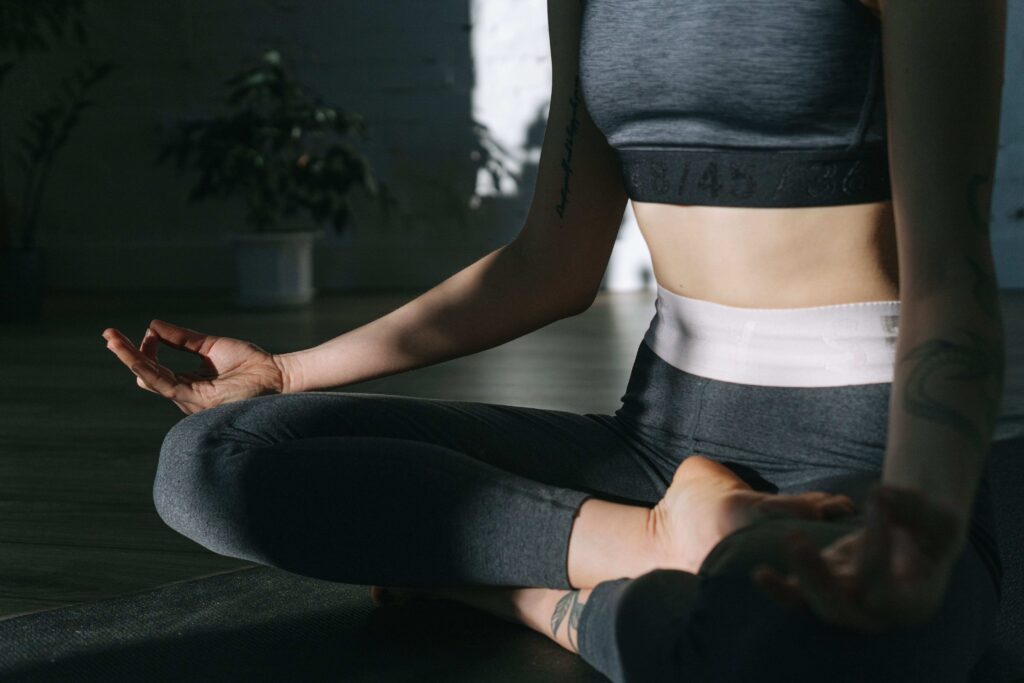 A person meditating in a yoga pose following a personal growth action plan. 