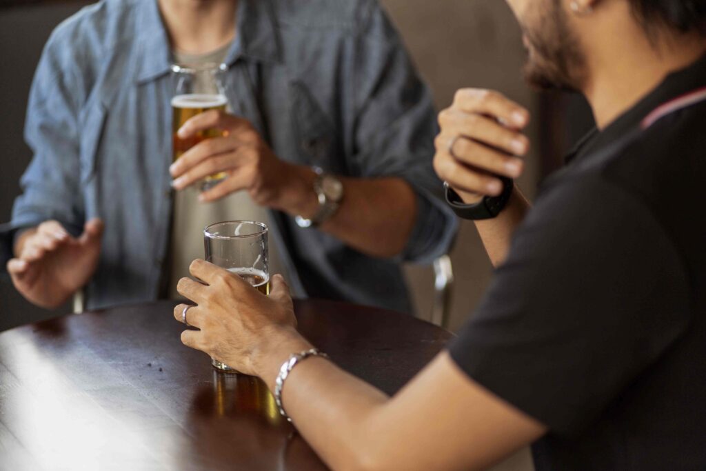 Close up of two people sharing real opinions over drinks, learning how to smoothly converse with strangers.