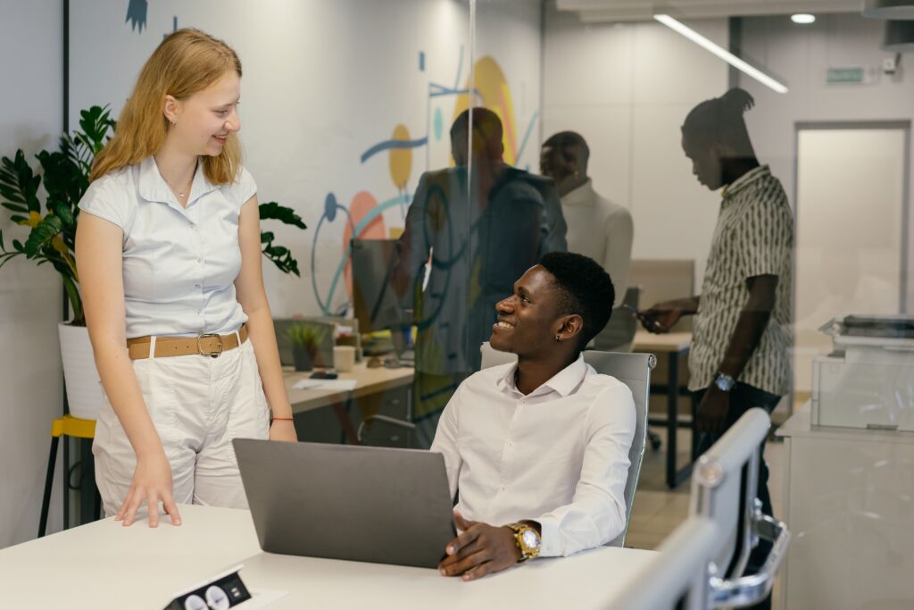 A woman smiling at a colleague at work practicing daily acts of kindness. 