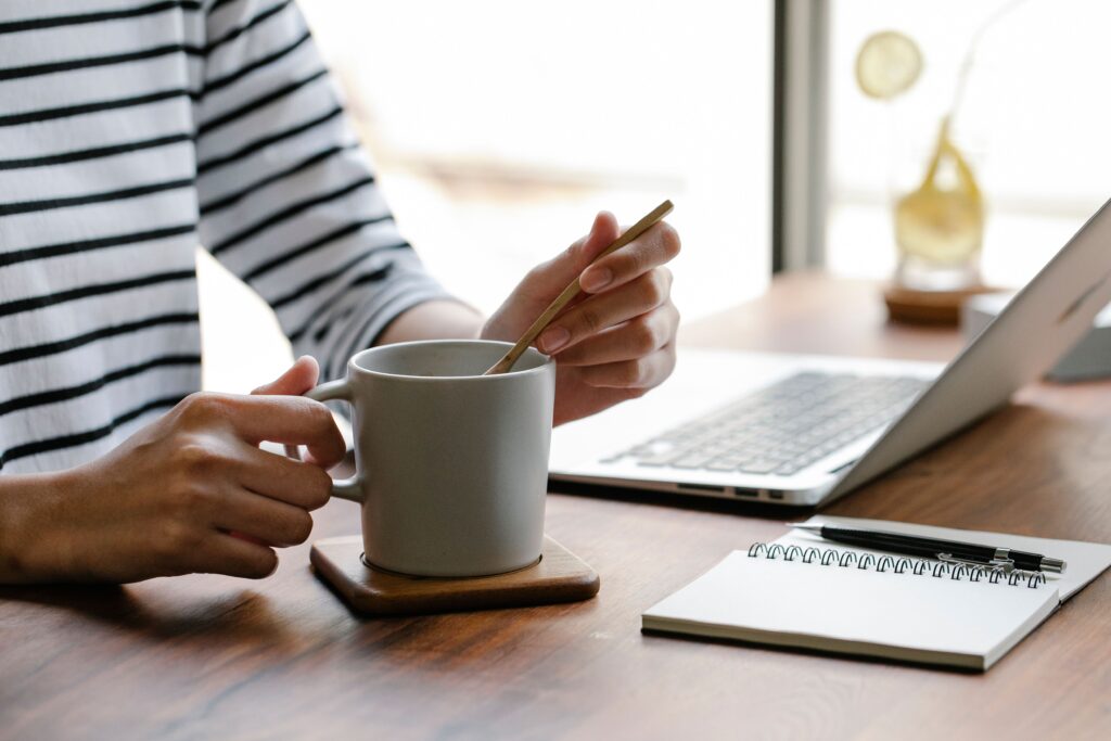 A person working and enjoying a drink learns how to be a better person through daily habits.