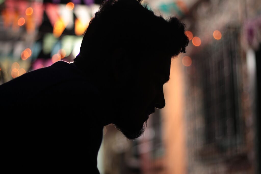 A silhouette of a man looking down while overcoming perfectionism. 