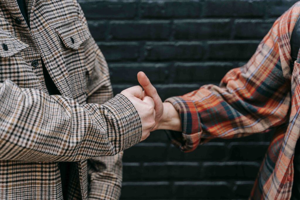 Close up of two people doing a hand shake showing deep platonic connection and mutual trust.