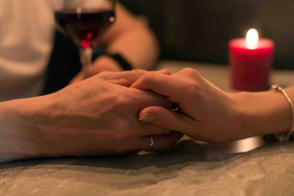 A couple holding hands at dinner following public displays of affection rules. 