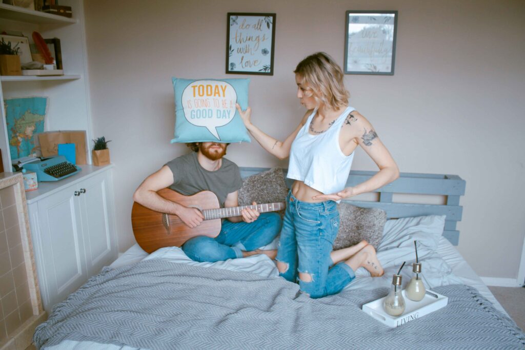 A couple sitting on bed illustrating loss of individuality in relationship and partner influence.