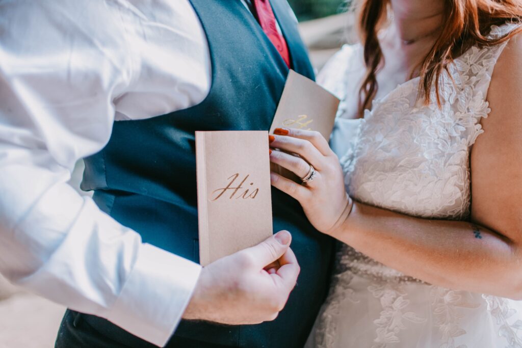 A bride and groom holding vow booklets written with deep love poems for her. 