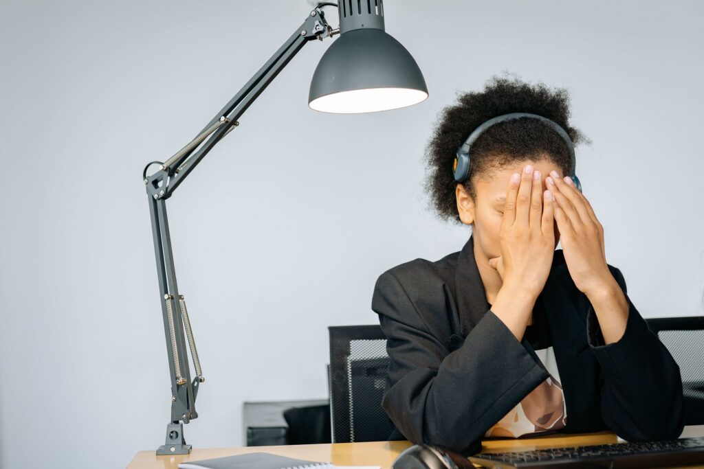 A stressed woman experiencing emotional overwhelm at work due to diffuse personal boundaries. 