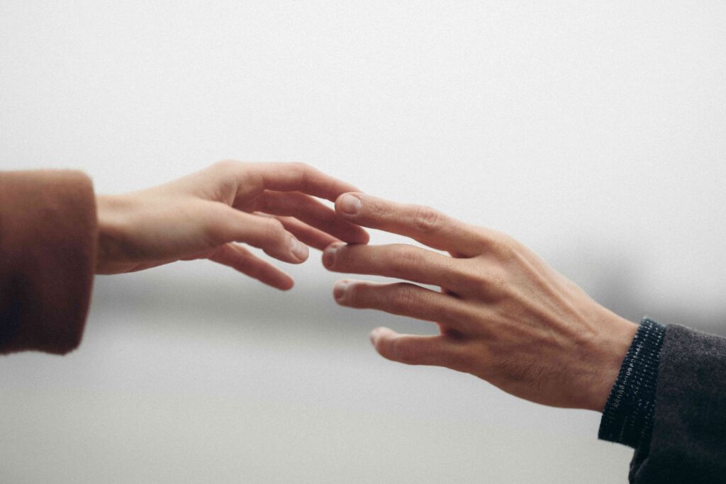 Two hands reaching out but not touching, symbolizing a right person wrong time relationship.