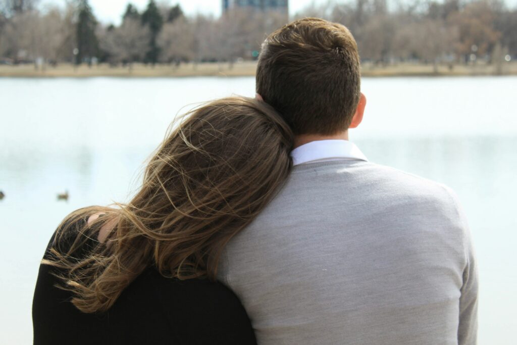 A couple sitting by a lake healing childhood attachment trauma in adults together.