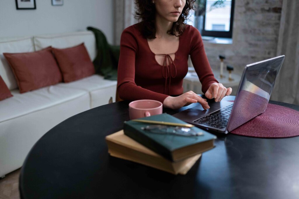 A woman working independently on her laptop at home avoiding signs of a clingy partner.