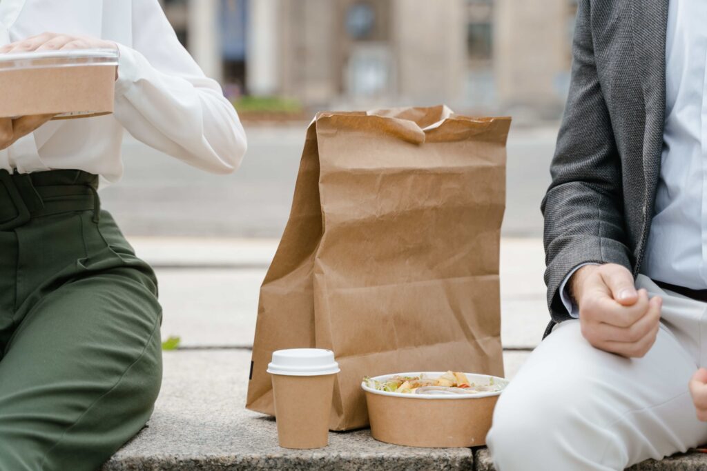 Two colleagues having a outdoor lunch break together maintaining a workplace platonic bond.