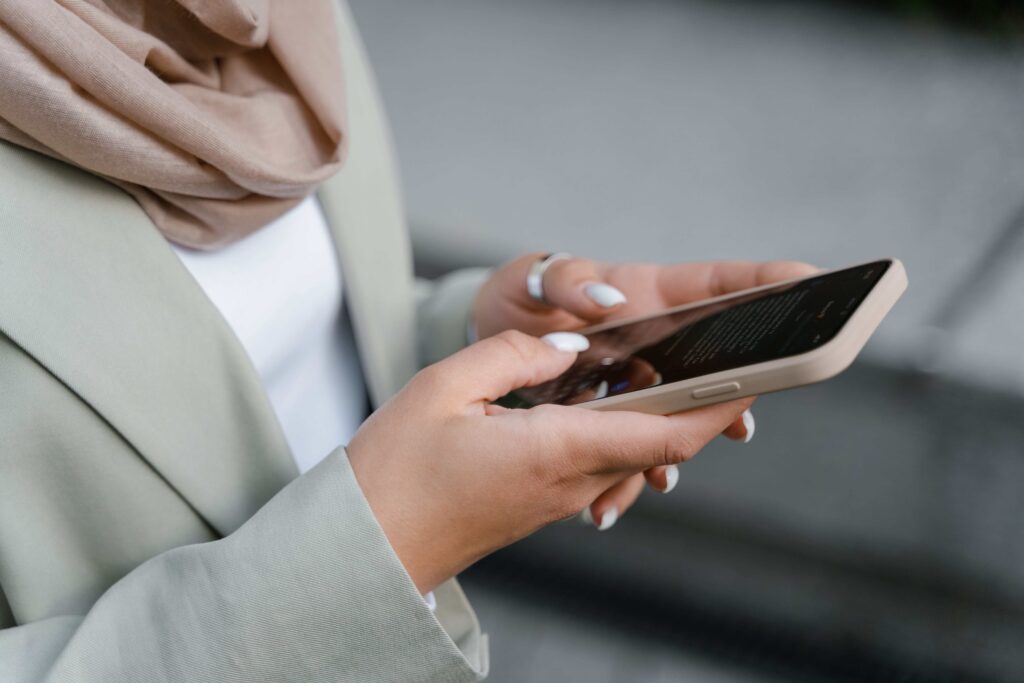 A person typing on a smartphone using rejection text scripts for dating apps.