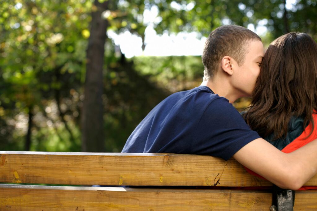 A couple sitting on a park bench illustrating the PDA meaning in relationship dynamics.