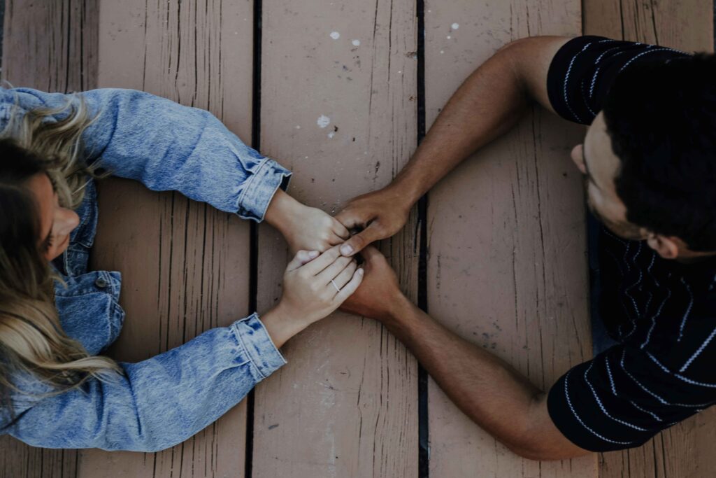 Top down view of a couple holding hands learning how to be kind together.