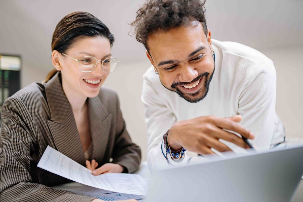 A male colleague ally working together on a document with a female coworker.