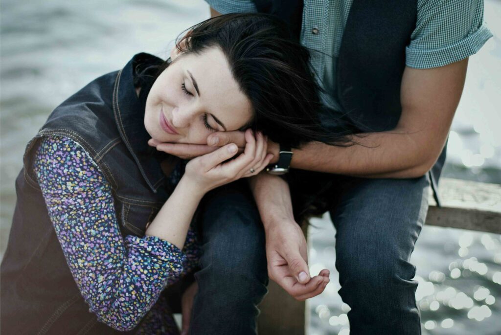 Clingy Girlfriend: 5 Hidden Habits Pushing Him Away A woman resting her head comfortably on her partner's shoulder as a clingy girlfriend.