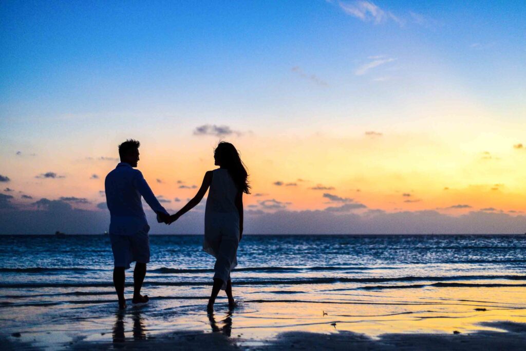 A couple holding hands at sunset inspired by romantic poems for her. 