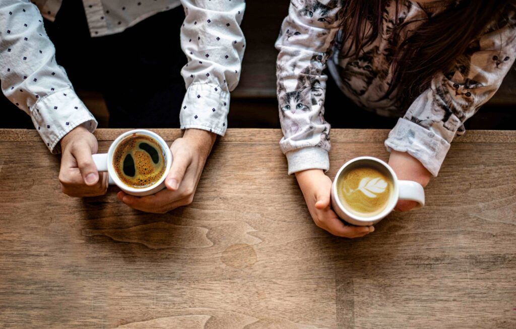 The Nice Person Guide: 7 Ways to Show You Care in Dating Two people holding coffee cups on a date following a nice person guide.