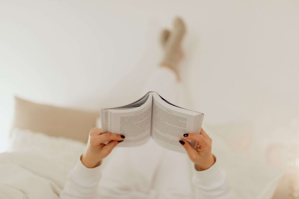A person relaxing in bed reading a book on betrayal fake friends quotes.
