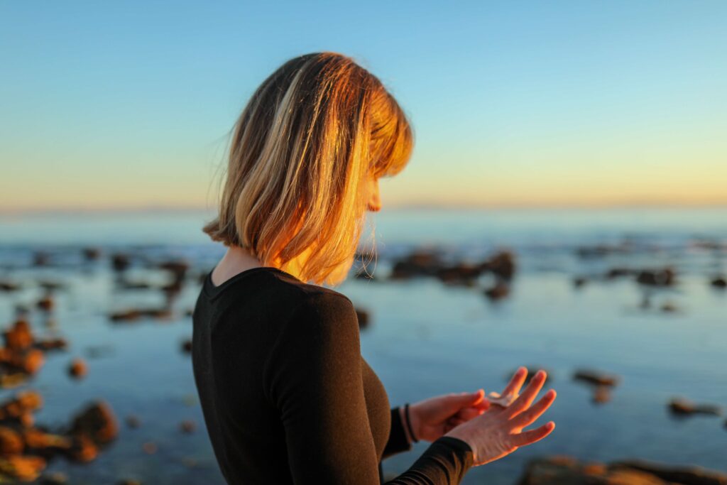 A woman looking down thoughtfully, reflecting on the time heals all wounds myth.