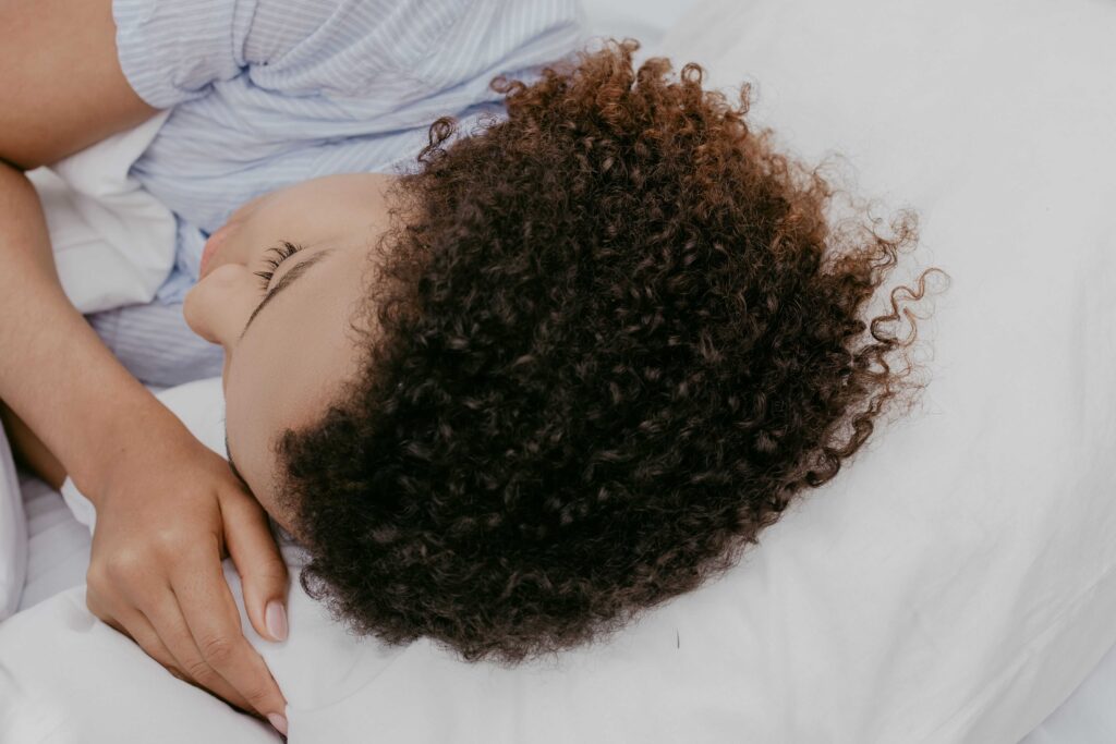 A woman sleeping peacefully in bed reflecting pregnancy dream meaning and unfulfilled desires.