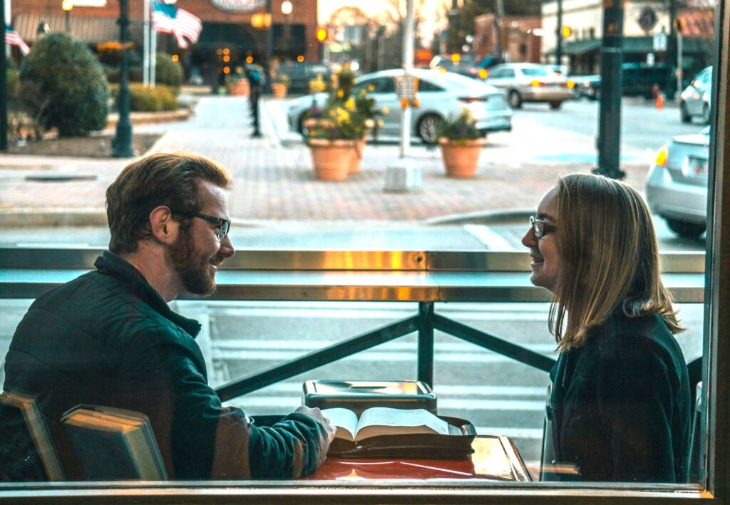 A couple chatting in a cozy cafe practicing a guide to being a nice person.