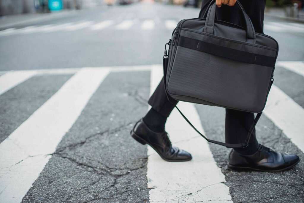 A professional holding a bag at a crosswalk explaining identity crisis definition.