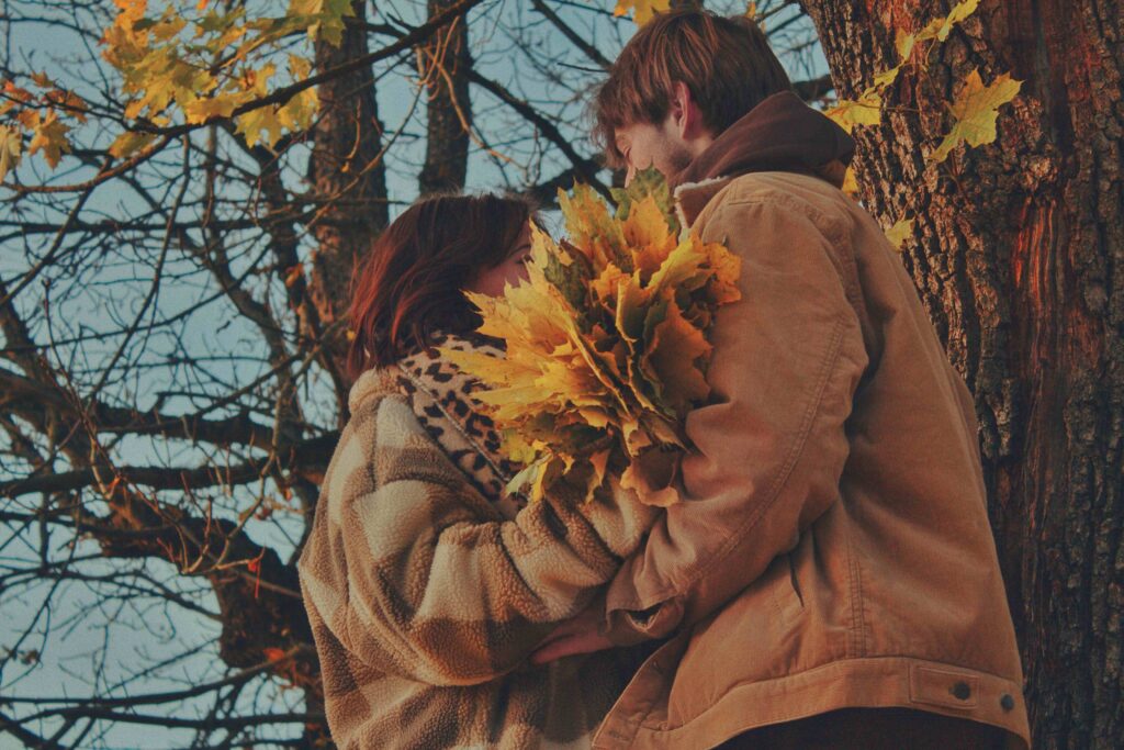 A couple embracing under autumn trees showing kind vs nice dynamic.