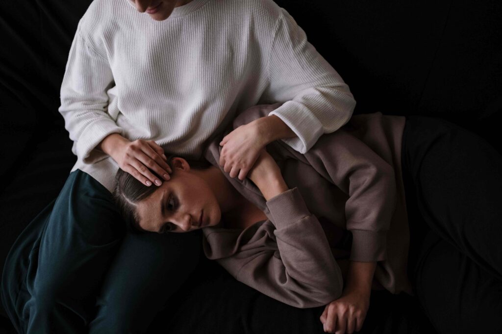 A woman resting her head on her partner's lap exploring why someone is clingy. 