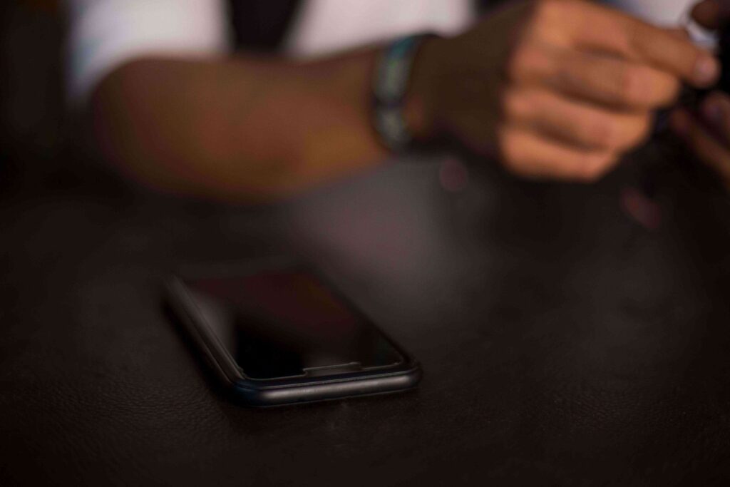 A person unreading and ignoring the smartphone lying on a dark table, showing the pain of losing the right person at the wrong time. 