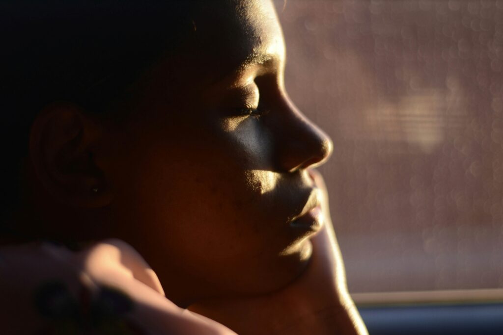 A person in shadow pondering if time heals all wounds or just numbs emotional pain. 