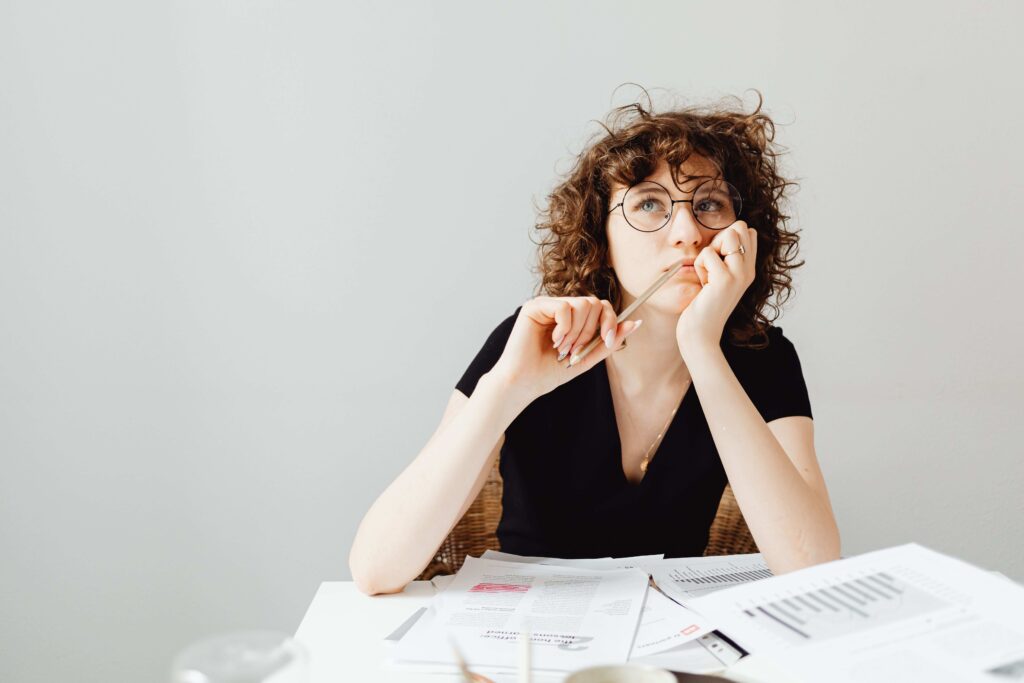 A woman sitting at desk thinking about a new project related to dreaming of having a baby metaphor.