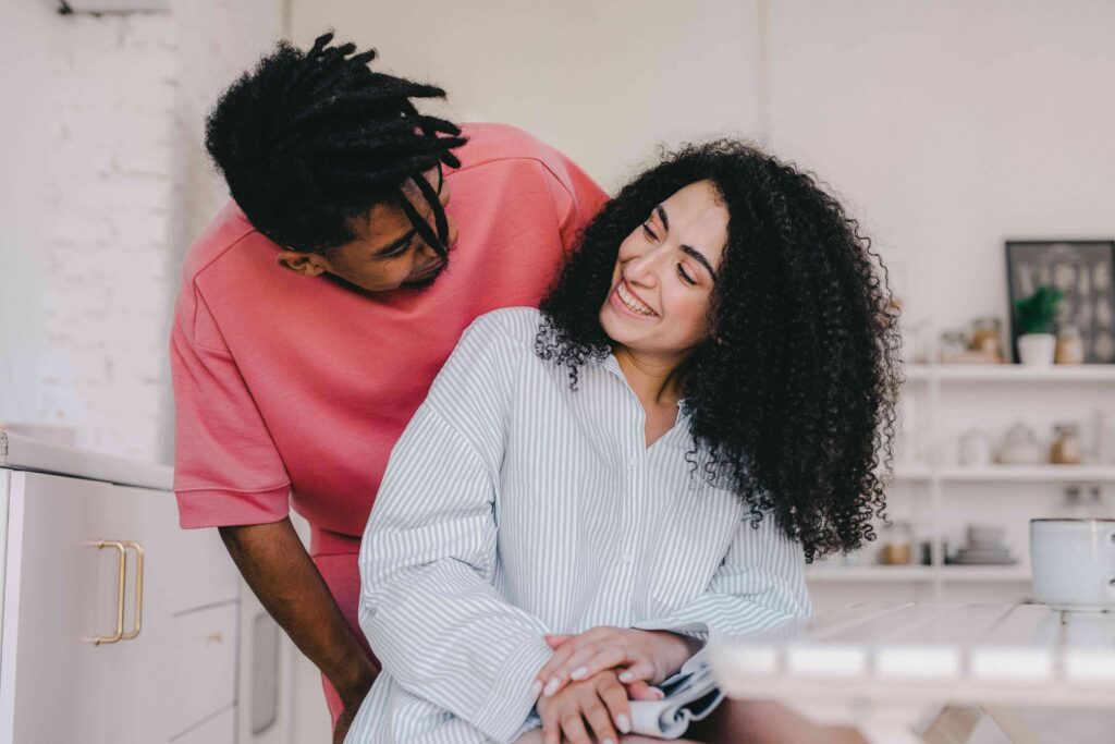 Black Cat and Golden Retriever: The Psychology of Opposite Attraction A smiling couple cuddling in the kitchen showing black cat golden retriever dynamic.