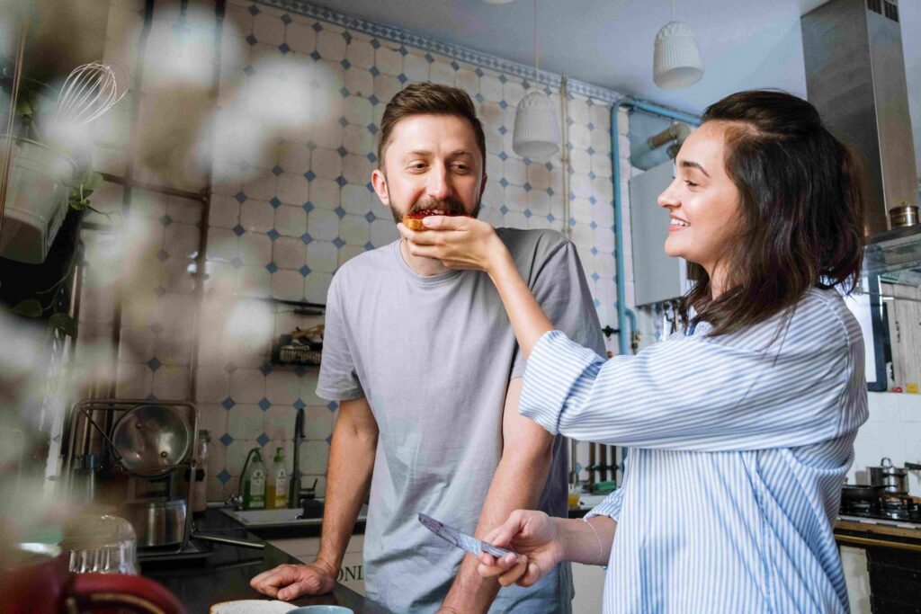 A joyful couple preparing breakfast together illustrating complementary personality types.