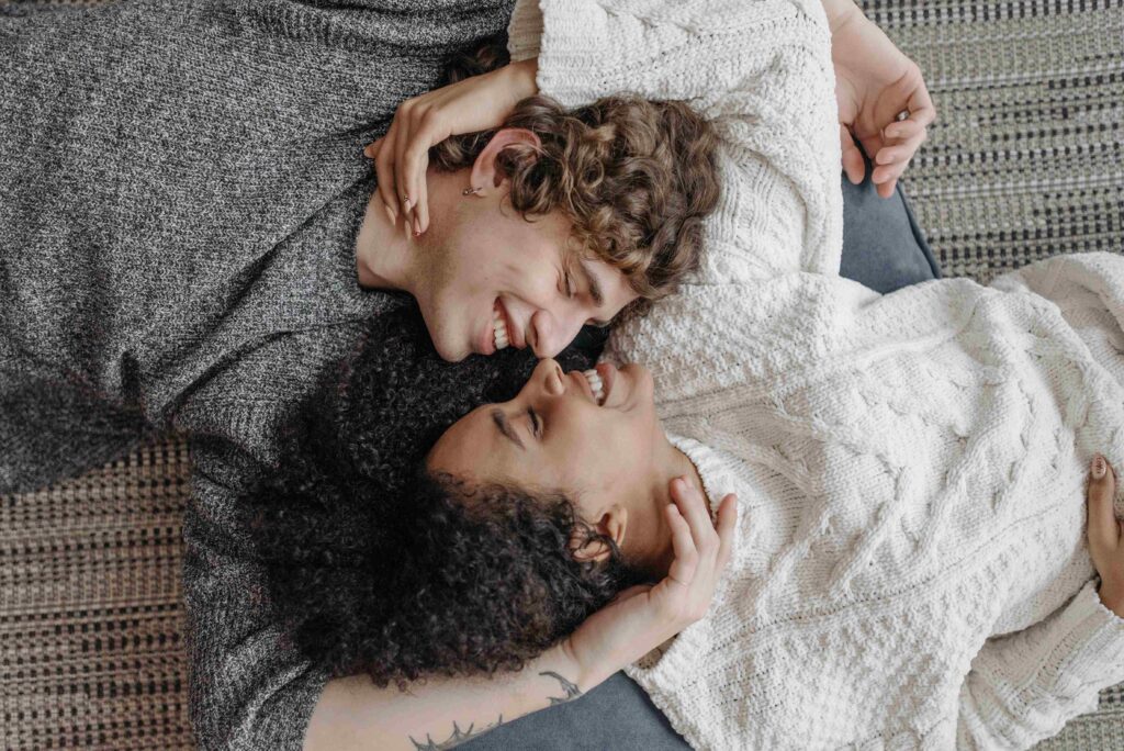 Bodily Kinesthetic Intelligence: Mastering the Physical Touch Language A couple lying on the floor in knit sweaters reflecting bodily kinesthetic intelligence.