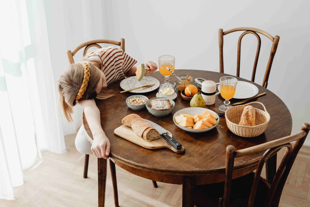 A depressed person resting head on the dinner table illustrating narcissistic parenting traits and exhaustion.