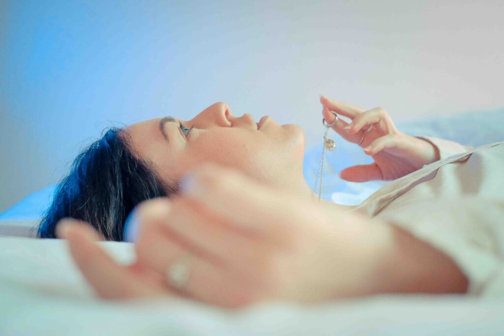 Emotional Detachment: How It Protects You, or Destroys Your Love A thoughtful woman lying in bed reflecting emotional detachment and feeling numb.