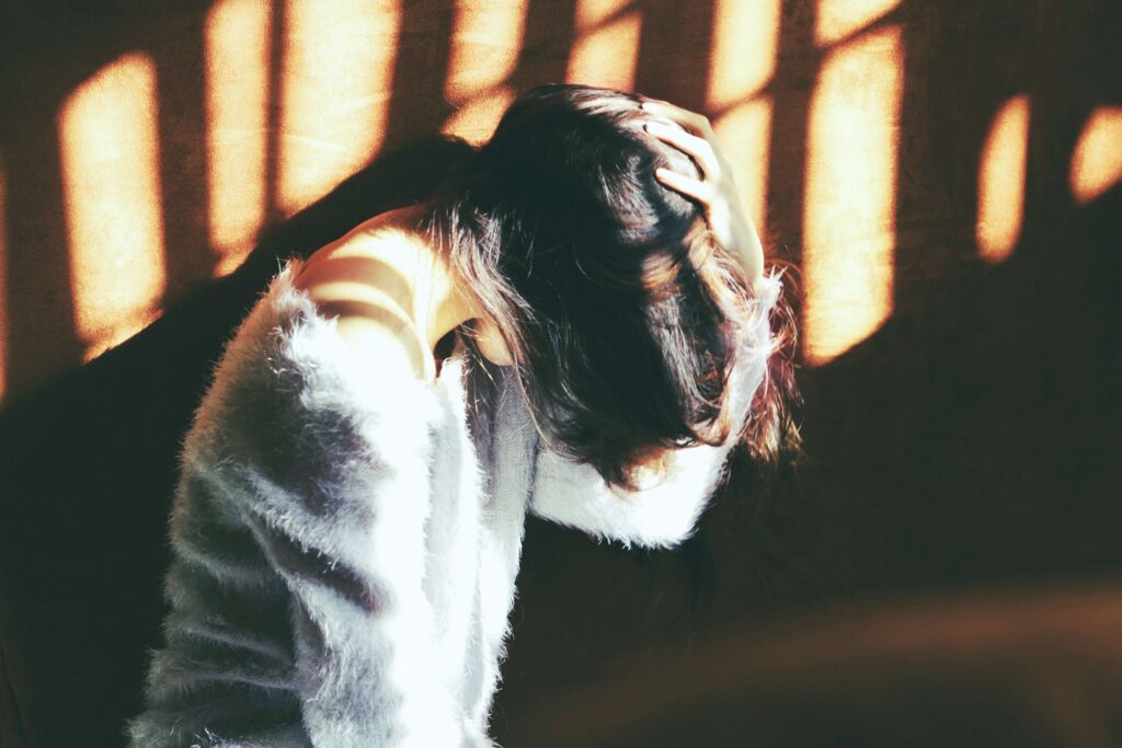 Emotional Shutdown: Why Your Partner Freezes & How to Respond A distressed person holding head in hands showing an involuntary emotional shutdown reflex.