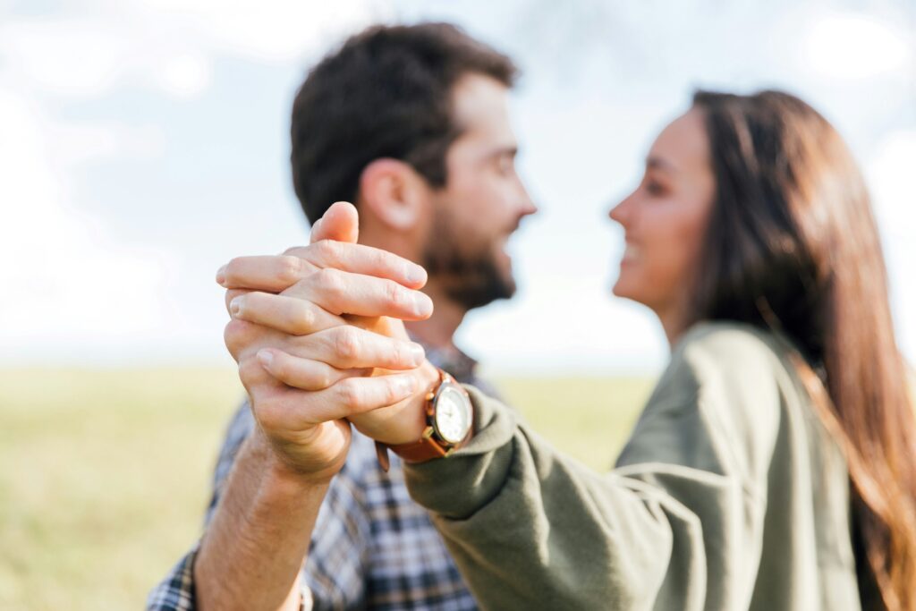 Emotions vs. Feelings: How They Shape Your Relationships A happy couple dancing outdoors reflecting emotions vs feelings and relational safety.