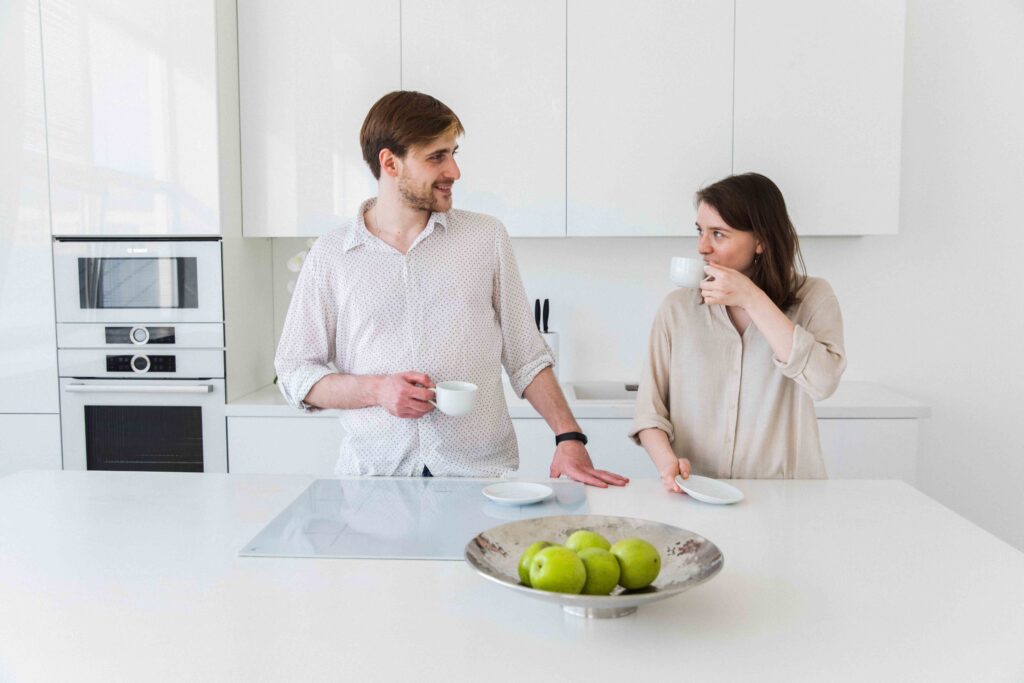A couple having coffee together in a modern kitchen using social emotional skills.