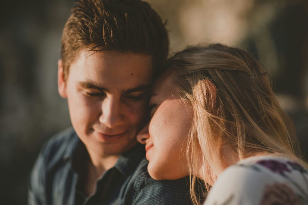 A young couple laughing and whispering together illustrating the biological basis of love and bonding.
