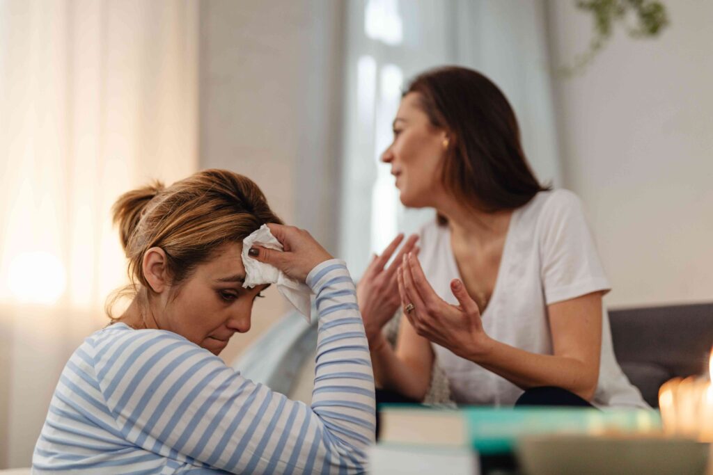 Two women talking across a table representing how to tell if someone is lying in conversation.