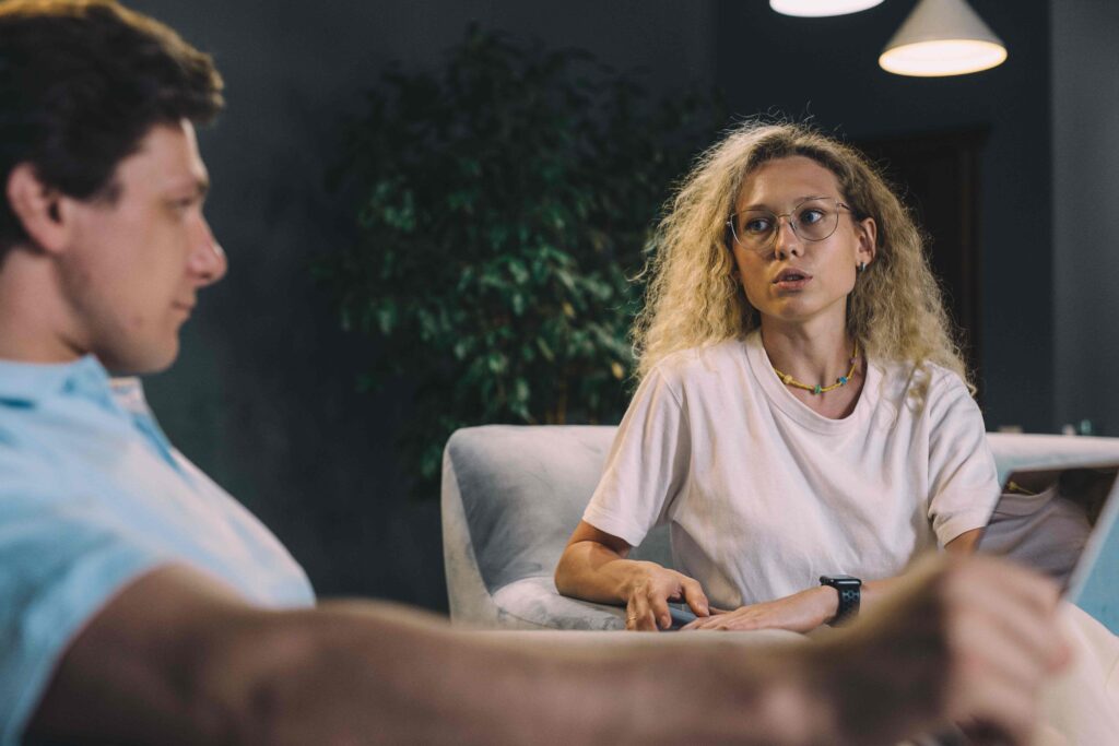A woman talking to a man in the living room showing emotional attunement in relationships.